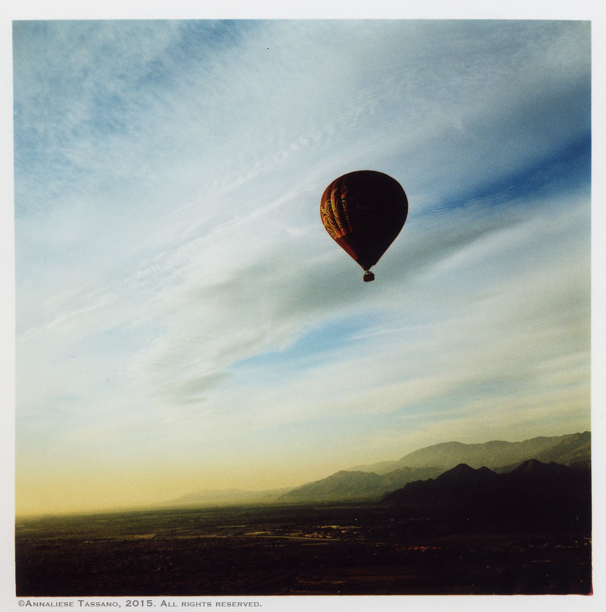 A cross process image of a balloon floating voer the desert valley of Palm SPrings, California.